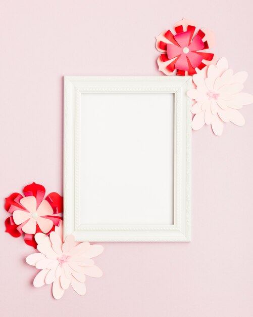 Top view of colorful paper flowers and frame