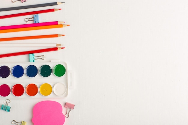 Top view colorful pencils with paints on white desk art drawing color paint