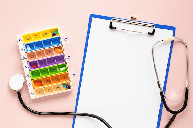 Top view colorful pillbox with stethoscope