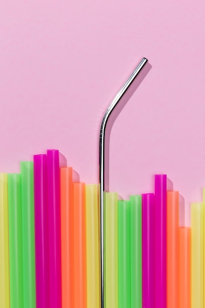 Вид сверху на разноцветные пластиковые соломинки, смешанные с металлом