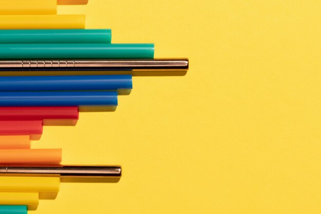 Top view of colorful plastic straws mixed with metal