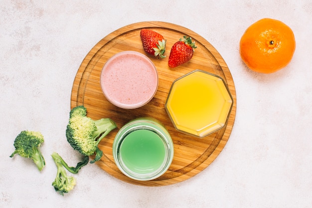 Top view colorful smoothies next to fruits 