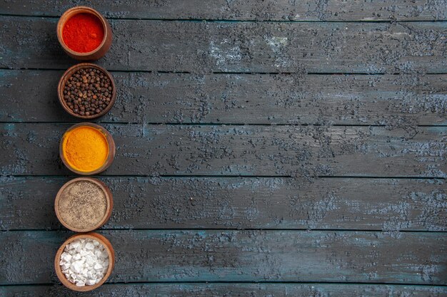 Top view colorful spices a row of different colorful spices on the left side of the table