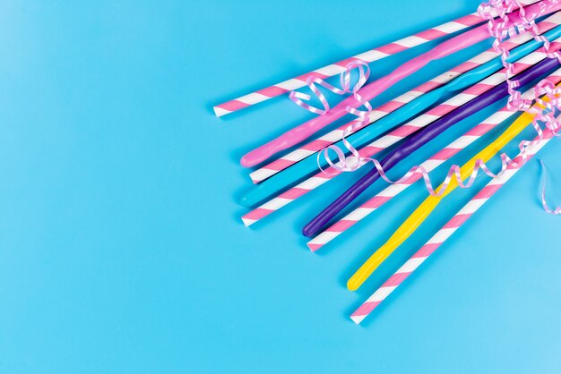 A top view colorful straws long sticky isolated on blue, drink juice cold color