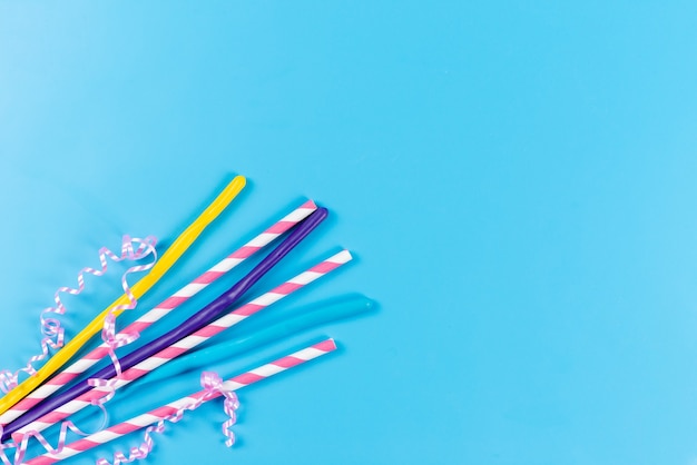 A top view colorful straws long sticky isolated on blue, drink juice cold color