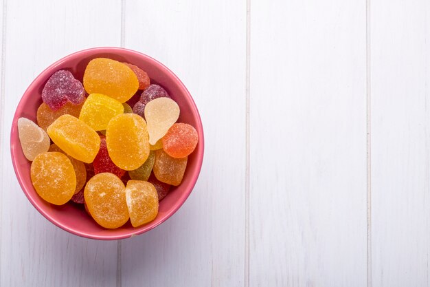 Top view of colorful tasty marmalade candies in a bowl on rustic