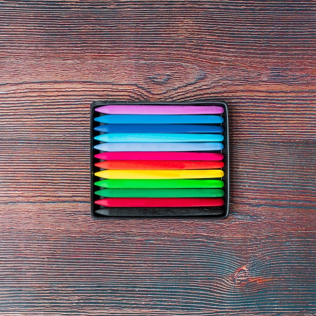 Free photo top view of colorful wax crayons on wooden table