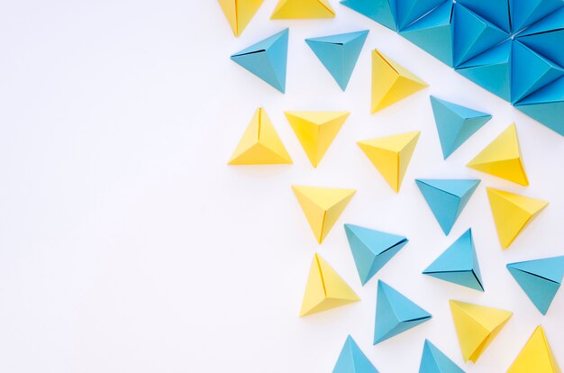 Top view of colourful paper pyramids and copy space