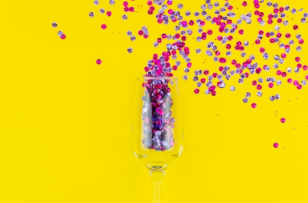 Top view colourful sequins in a wine glass