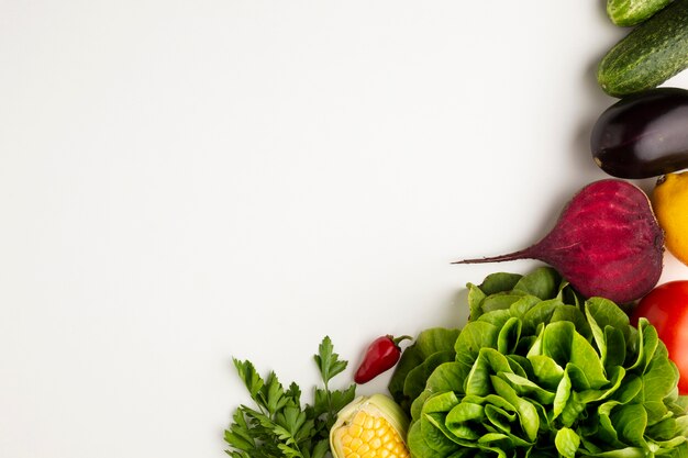 Top view colourful veggies on white background with copy space