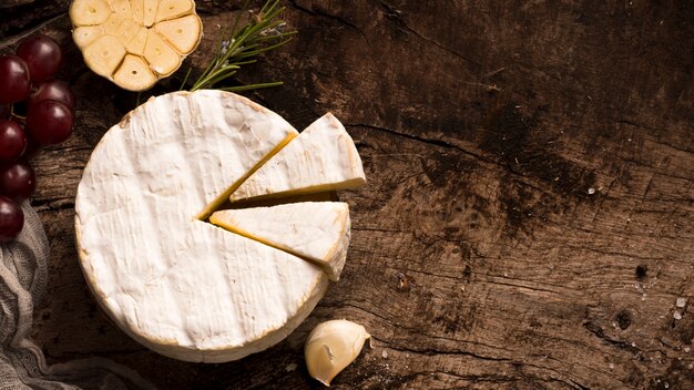 Top view composition of different delicacies on wooden table with copy space