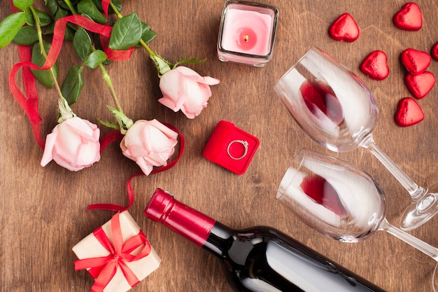 Top view composition with wine bottle and engagement ring