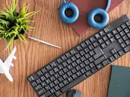 Free photo top view concept image of businessman on wooden des, pot of grass, headphones, books