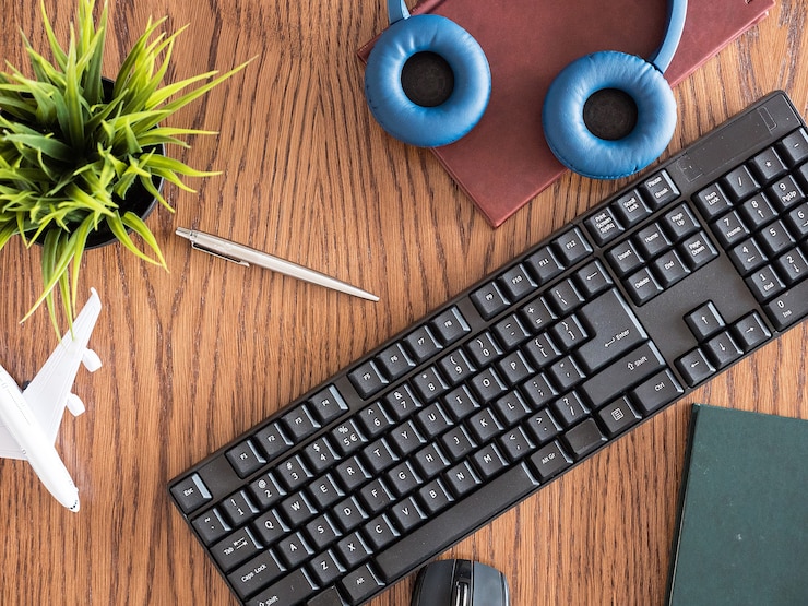 Free Photo top view concept image of businessman on wooden des, pot of grass, headphones, books