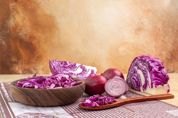 Top view a concept with fresh onions and a bowl of chopped red cabbage for homemade vegetable salad with space for text