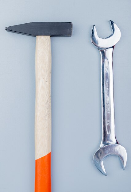 Top view of construction tools as brick hammer and open-end wrench on gray background