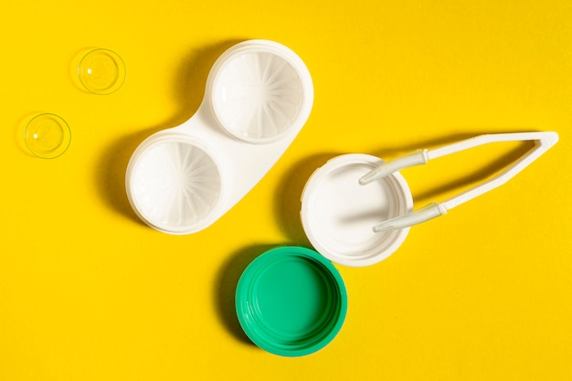 Free photo top view of contact lenses case and tweezers