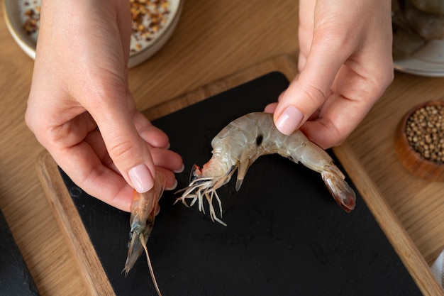 Free photo top view cook cleaning shrimp in kitchen