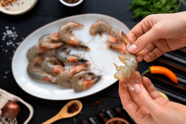 Free photo top view cook cleaning shrimp in kitchen