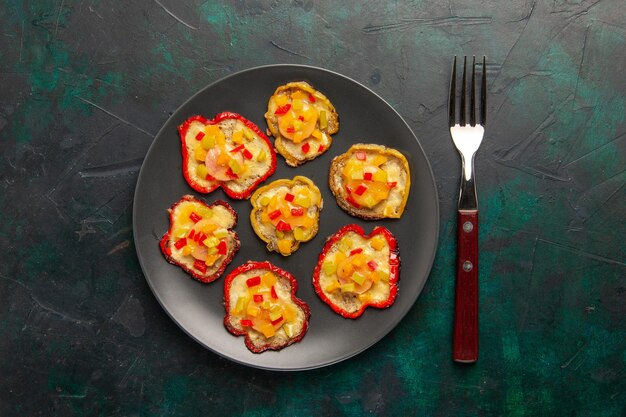 Top view cooked bell-peppers for lunch inside grey plate on dark surface