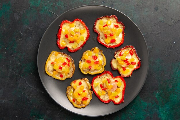 Top view cooked bell-peppers for lunch inside plate on dark surface