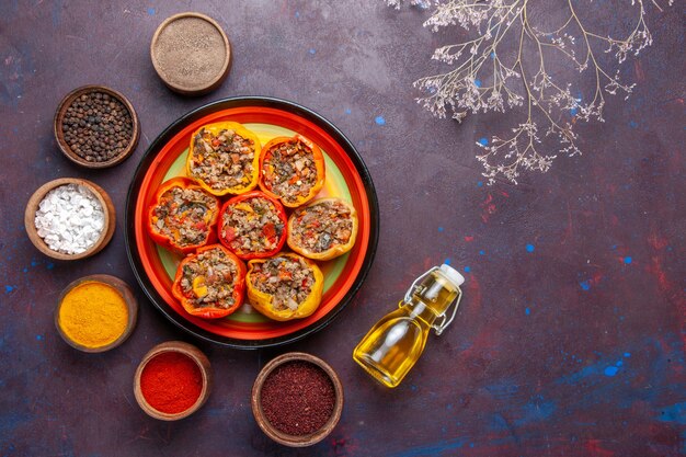 Top view cooked bell-peppers with different seasonings on dark grey surface food dolma vegetable meal beef