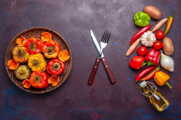 Top view cooked bell-peppers with fresh vegetables on a dark surface meal vegetable food meat dolma