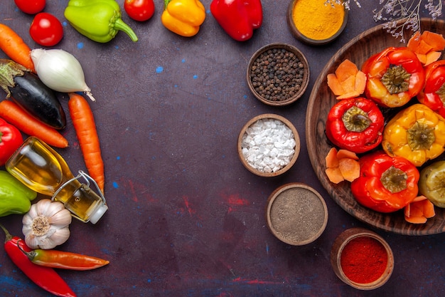 Free photo top view cooked bell-peppers with fresh vegetables and seasonings on a grey surface meal dolma food vegetable beef meat