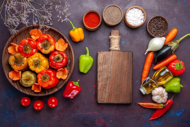 Top view cooked bell-peppers with fresh vegetables and seasonings on grey surface meal dolma vegetables beef meat