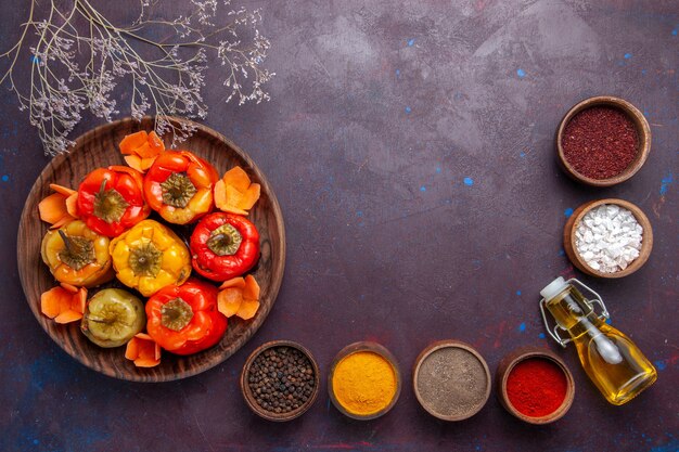 Top view cooked bell-peppers with ground meat and different seasonings on dark surface meat vegetable beef meal food