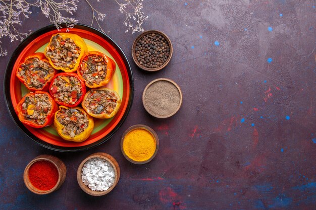 Top view cooked bell-peppers with ground meat and different seasonings on a grey surface meal dolma food vegetables beef meat