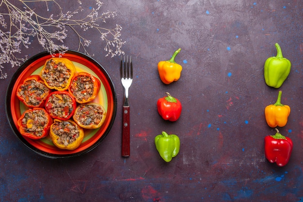 Foto gratuita vista dall'alto peperoni cotti con carne macinata sulla superficie grigia carne di manzo dolma cibo vegetale