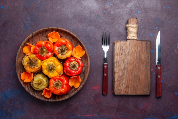 Foto gratuita vista dall'alto peperoni cotti con carne macinata all'interno sulla superficie grigia pasto carne cibo cucina vegetale