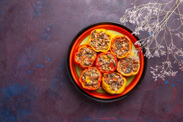 Top view cooked bell-peppers with ground meat inside plate on dark grey surface food dolma vegetable meal beef