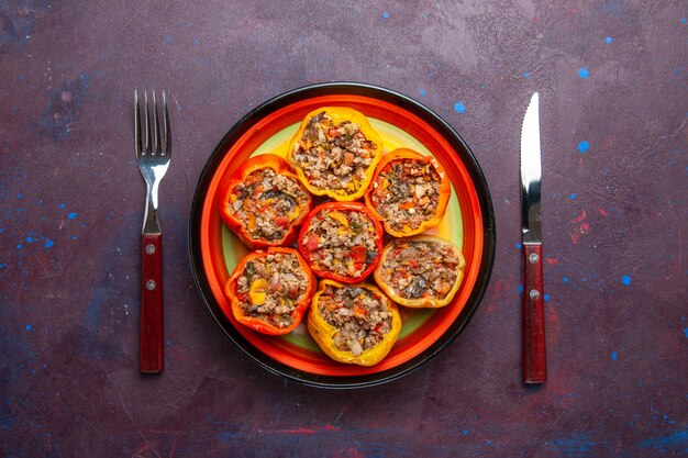 Top view cooked bell-peppers with ground meat mixed with seasonings on a grey surface meal dolma food vegetables beef meat