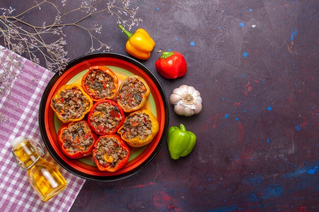 Top view cooked bell-peppers with ground meat and oil on a dark desk meal vegetables food meat dolma