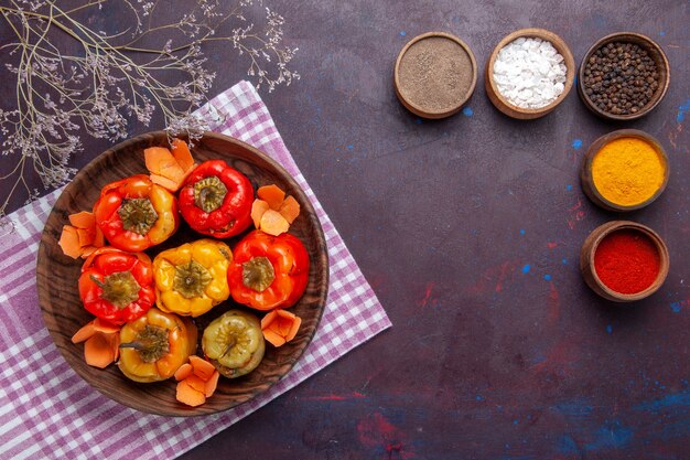 Top view cooked bell-peppers with ground meat and seasonings on dark surface meat vegetable beef meal food