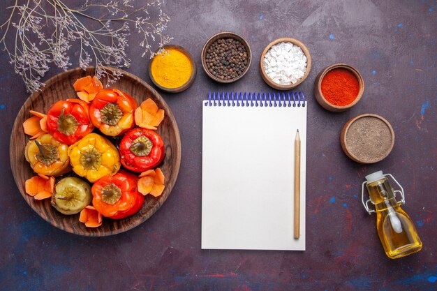 Top view cooked bell-peppers with ground meat and seasonings on dark surface meat vegetables beef meal food