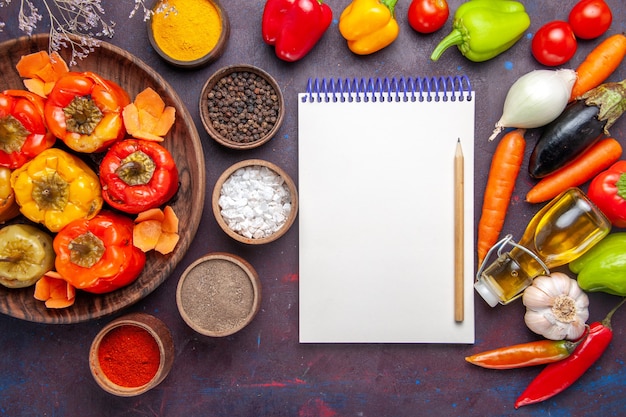 Top view cooked bell-peppers with seasonings and fresh vegetables on a grey surface meal vegetables meat dolma food