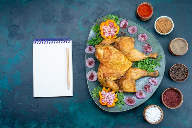 Foto gratuita vista dall'alto pollo cotto con cipolle e verdure all'interno del piatto sulla scrivania blu scuro carne di pollo cuocere la cena al forno