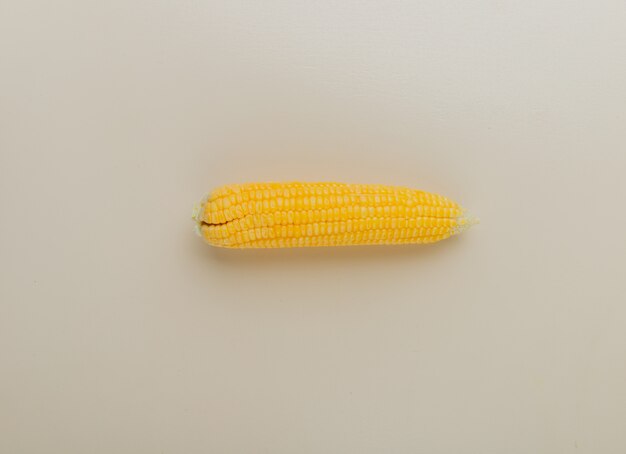 Top view of cooked corn on white surface with copy space