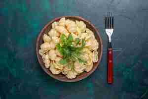 Free photo top view cooked dough pasta with greens inside plate on the dark desk