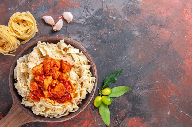 Top view cooked dough with chicken and sauce on dark surface dark pasta dough dish