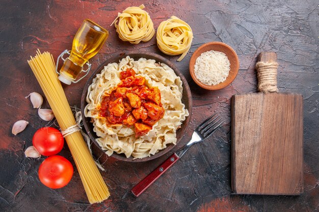 Top view cooked dough with rice and sauced meat on dark surface dark pasta dough dish