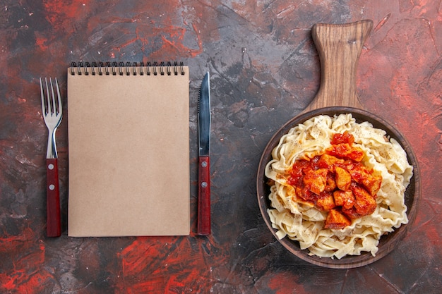 Top view cooked dough with sauce meat on dark floor dough dark pasta dish