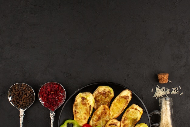 top view cooked eggplant inside black plate on the dark background