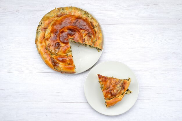 Top view cooked greens pastry round inside white plate on the bright desk meal food pastry lunch greens