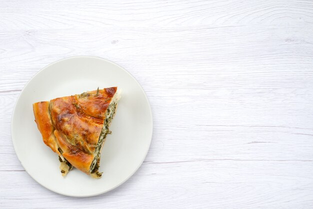 Вид сверху приготовленная зелень, тесто, нарезанное внутри белой тарелки на белом фоне, еда, печенье, обед, зелень