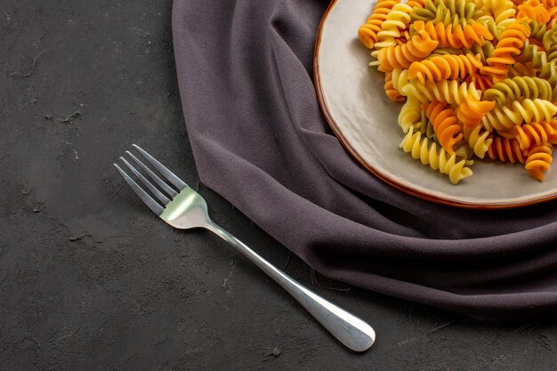 暗い机の上の皿の中のイタリアン パスタ珍しいスパイラル パスタ パスタ ミール ディナー フード料理料理のトップ ビュー
