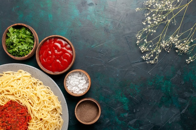 Top view cooked italian pasta with meat and different seasonings on the dark-blue surface